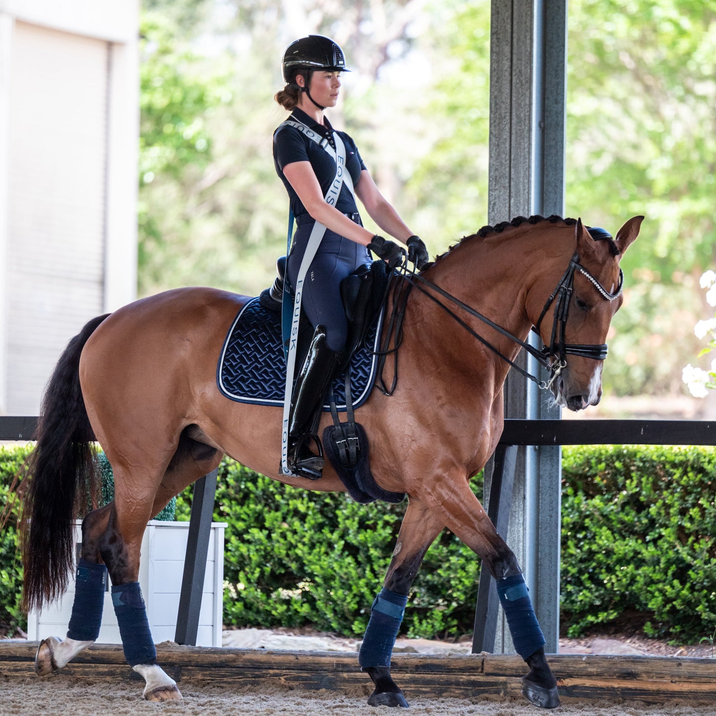 Person riding a horse in an outdoor equestrian setting